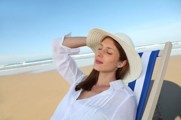Krásná žena odpočívá v lehátku na pláži — Stock fotografie
