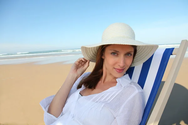 美しい女性のビーチでデッキチェアで休んで — ストック写真