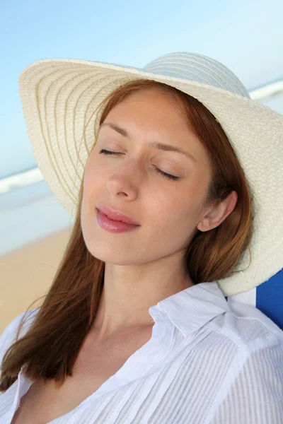 Beautiful woman resting in deckchair at the beach — Stock Photo, Image