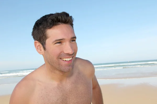 Χαμογελαστός άνθρωπος τζόκινγκ σε μια αμμώδη παραλία — Φωτογραφία Αρχείου
