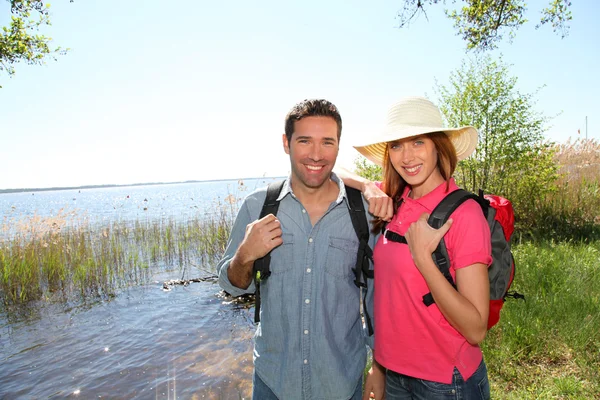 Šťastný pár turistika u jezera — Stock fotografie