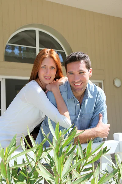Jeune couple assis devant leur nouvelle maison — Photo