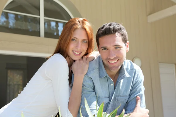 Junges Paar sitzt vor seinem neuen Haus — Stockfoto