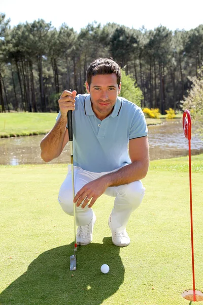 Golfista arrodillado delante de la pelota de golf — Foto de Stock
