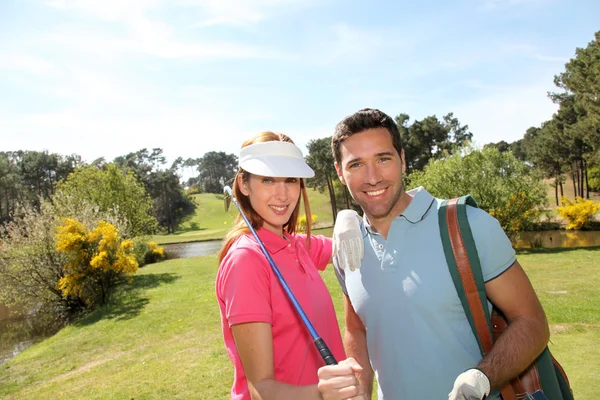 Casal jogando golfe em um dia ensolarado — Fotografia de Stock