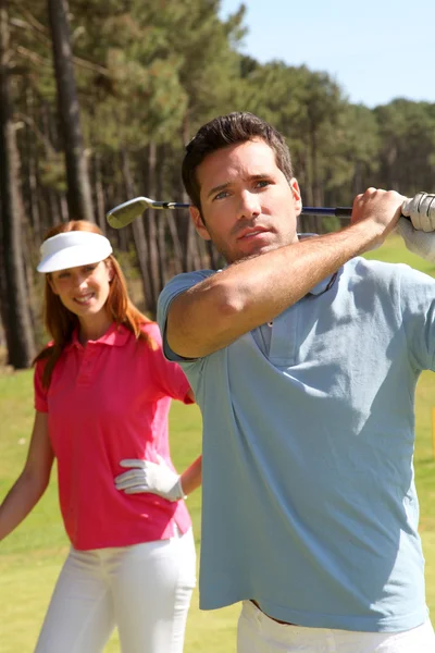 Pareja jugando al golf en un día soleado — Stockfoto