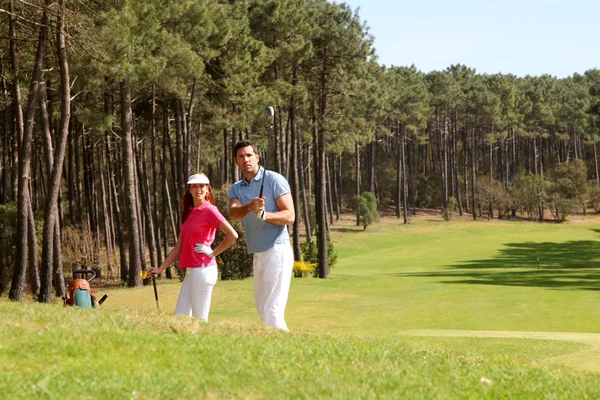 Casal jogando golfe em um dia ensolarado — Fotografia de Stock