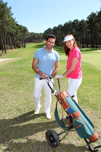 Пара играющая в гольф в солнечный день — стоковое фото