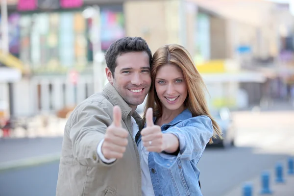 Lyckliga paret med tummen upp i stan — Stockfoto