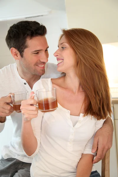 Couple in home kitchen drinking tea — Stock Photo, Image