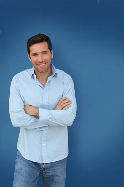 Portrait of handsome man standing on blue background — Stock Photo, Image