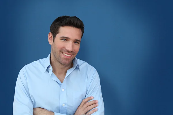 Portrait of handsome man standing on blue background — Stock Photo, Image