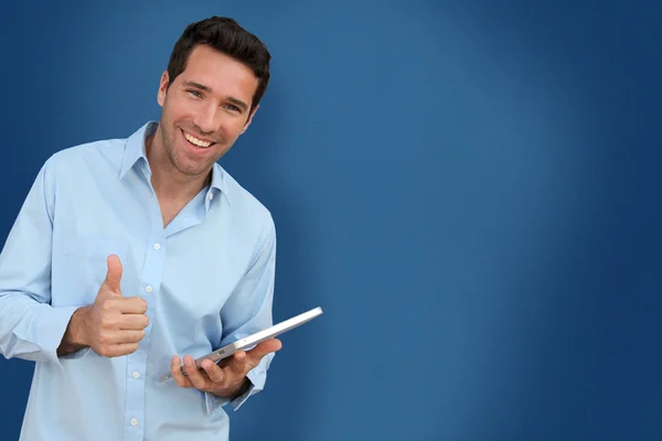 Aantrekkelijke man met touchpad op blauwe achtergrond — Stockfoto
