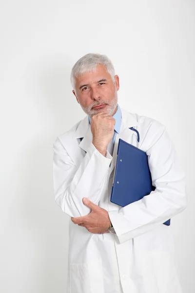 Старший врач с рукой на подбородке — стоковое фото