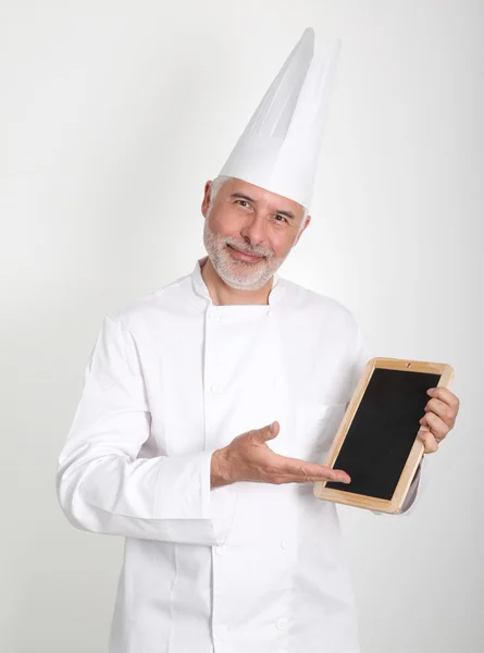 Chef souriant montrant le menu du restaurant — Photo