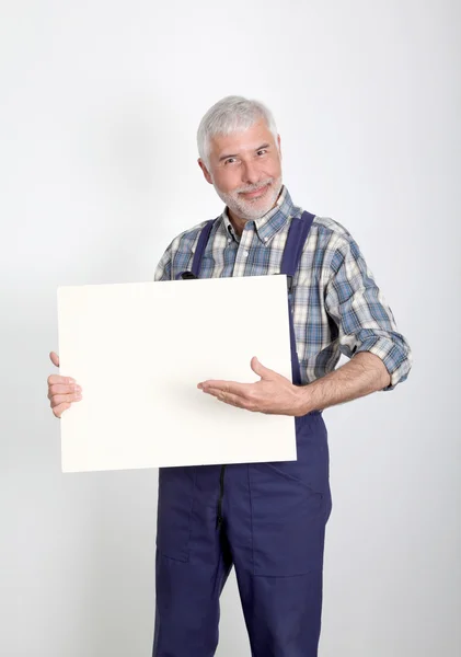 Retrato de artesão mostrando placa branca — Fotografia de Stock