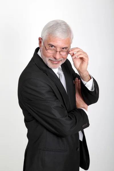 Senior affärsman med glasögon står på vit bakgrund — Stockfoto