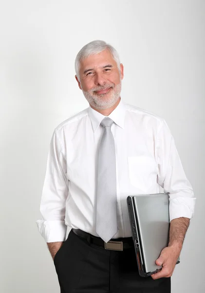 Uomo d'affari in piedi con computer portatile — Foto Stock