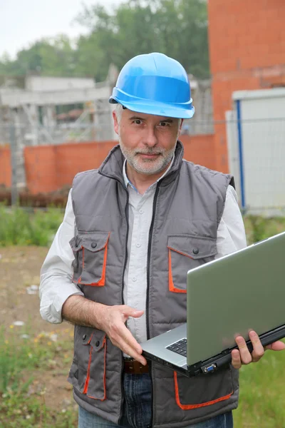 Gerenciador de site com computador portátil verificando a construção — Fotografia de Stock