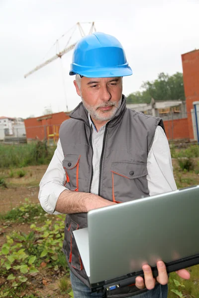 Менеджер сайта с ноутбуком, проверяющим конструкцию — стоковое фото