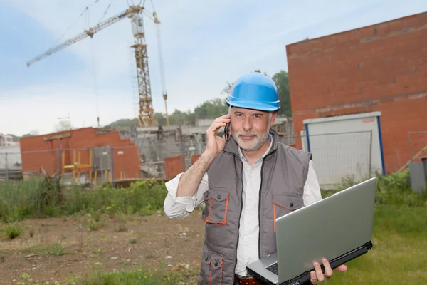 Direttore di costruzione in cantiere con computer portatile — Foto Stock