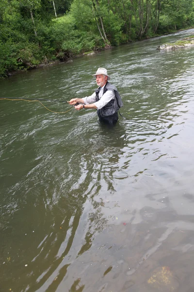 Mann angelt Forelle im Fluss — Stockfoto