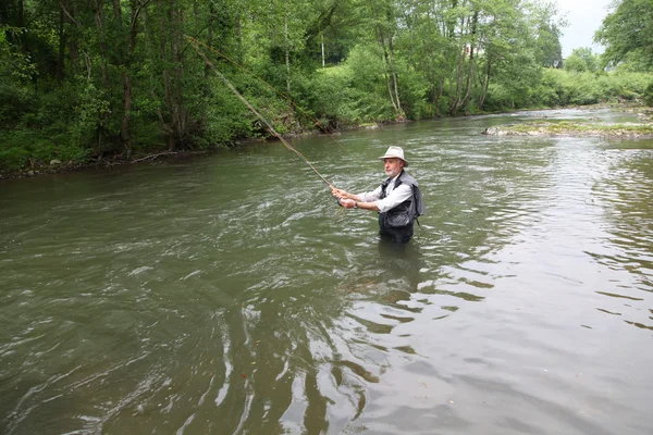 Hombre pescando trucha en el río — Foto de Stock