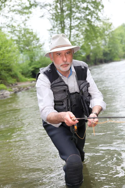 Hombre pescando trucha en el río — Foto de Stock