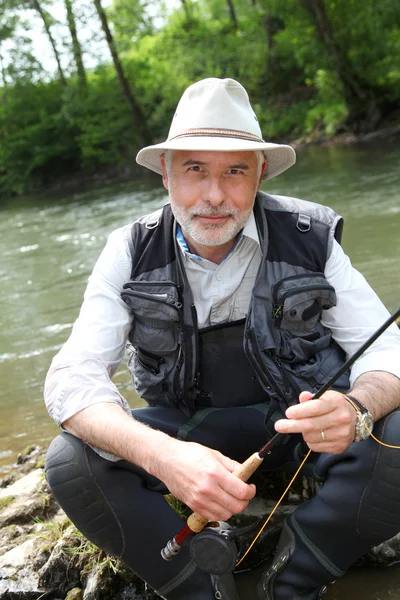 Портрет рыбака, сидящего у реки — стоковое фото