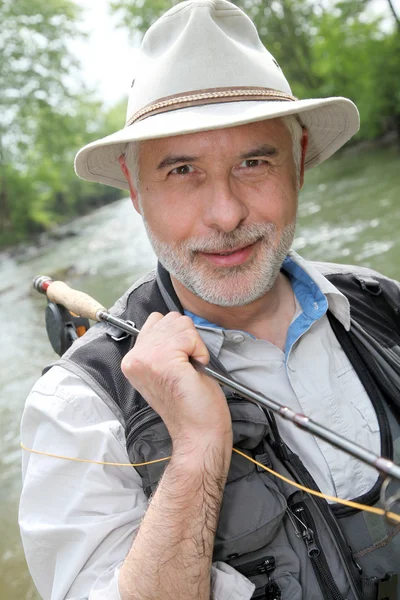 Портрет улыбающегося рыбака на берегу реки — стоковое фото