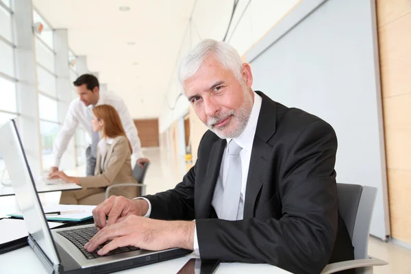 Senior zakenman die op laptopcomputer werkt — Stockfoto