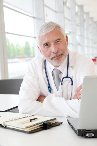 Portret starszego lekarza w biurze — Zdjęcie stockowe