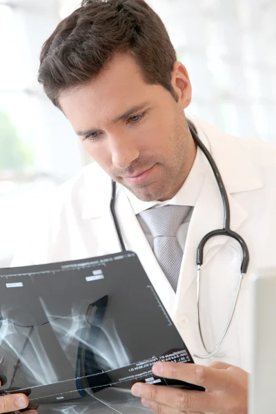 Retrato del joven médico revisando rayos X — Foto de Stock