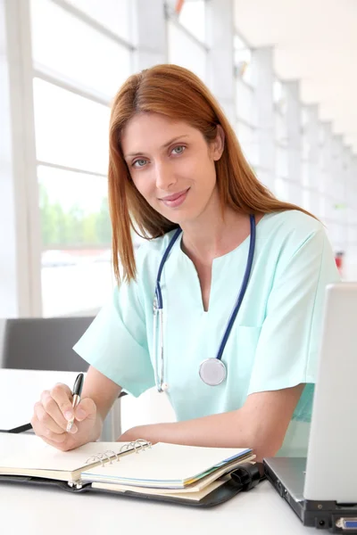 Медсестра, работающая на ноутбуке в больнице — стоковое фото