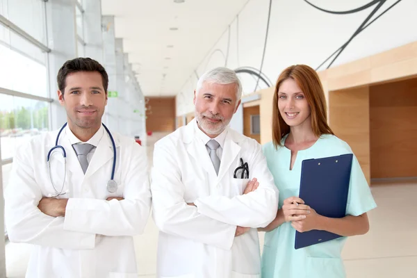 Портрет бригады врачей, стоящей в больничном зале — стоковое фото