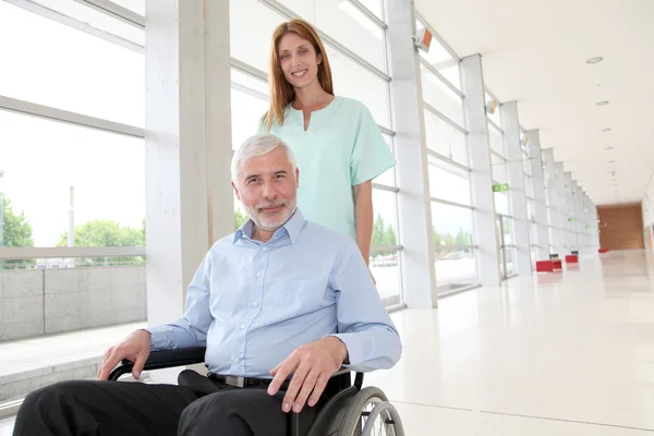 Pielęgniarka pomoc starszy człowiek na wózku inwalidzkim — Zdjęcie stockowe