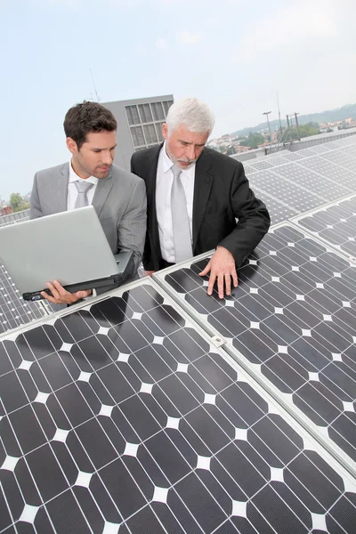 Negócios em pé por painéis solares — Fotografia de Stock
