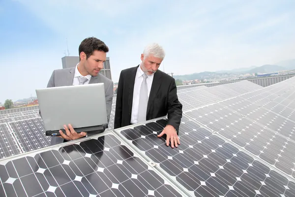 Business standing by solar panels — Stock Photo, Image
