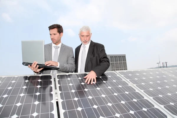 太陽電池パネルによって立っている実業家 — ストック写真