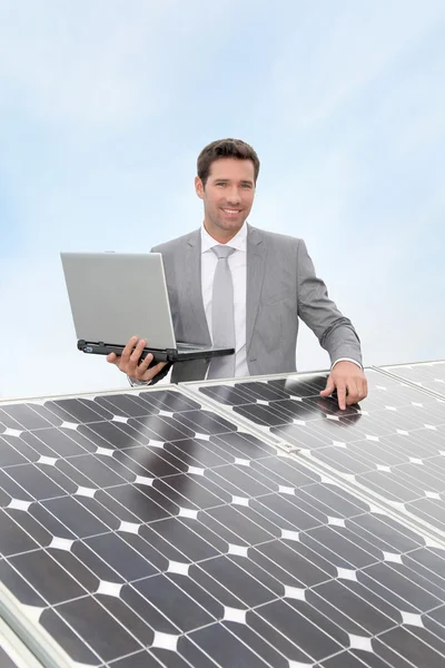 Επιχειρηματίας που στέκεται από ηλιακούς συλλέκτες — Φωτογραφία Αρχείου