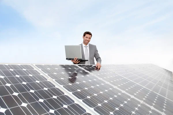 Επιχειρηματίας που στέκεται από ηλιακούς συλλέκτες — Φωτογραφία Αρχείου