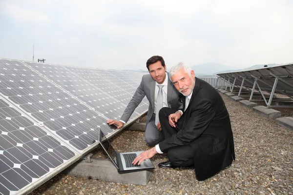 Бізнесмени перевіряють роботу сонячних панелей — стокове фото