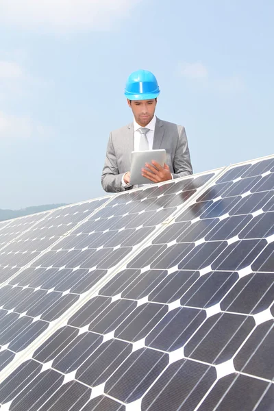 Επιχειρηματίας που στέκεται στην εγκατάσταση ηλιακών πάνελ — Φωτογραφία Αρχείου