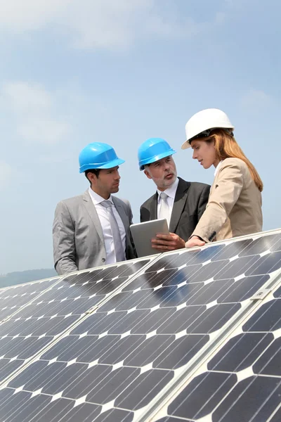 Engenheiros verificando a configuração de painéis solares — Fotografia de Stock