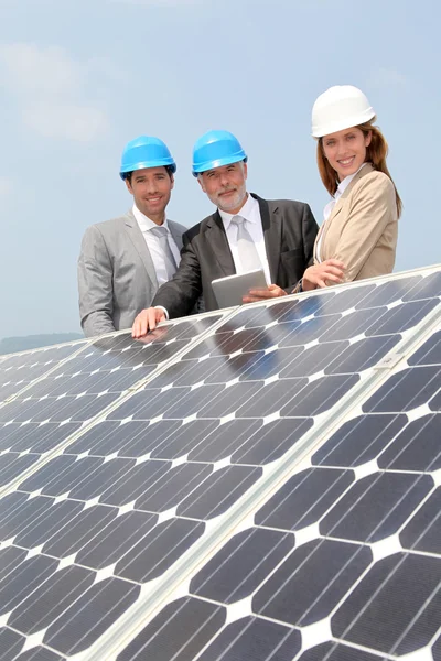 Engenheiros verificando a configuração de painéis solares — Fotografia de Stock