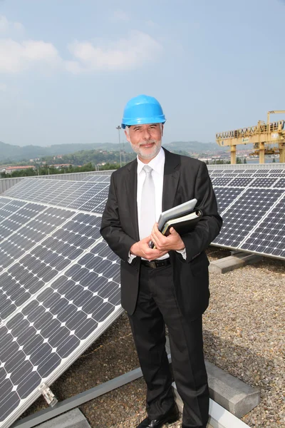Επιχειρηματίας που στέκεται στην εγκατάσταση ηλιακών πάνελ — Φωτογραφία Αρχείου