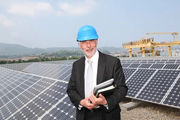 Бізнесмен стоїть на установці сонячної панелі — стокове фото