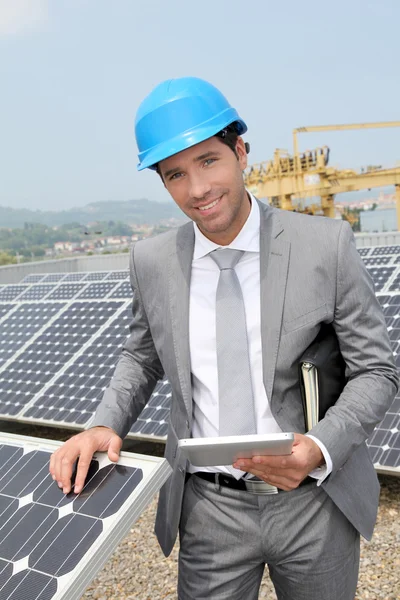 Businessman standing on solar panel installation — Stock Photo, Image
