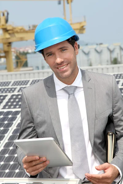 Biznesmen stojąc na instalację kolektorów słonecznych — Zdjęcie stockowe