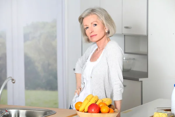 Старшая женщина стоит на кухне — стоковое фото